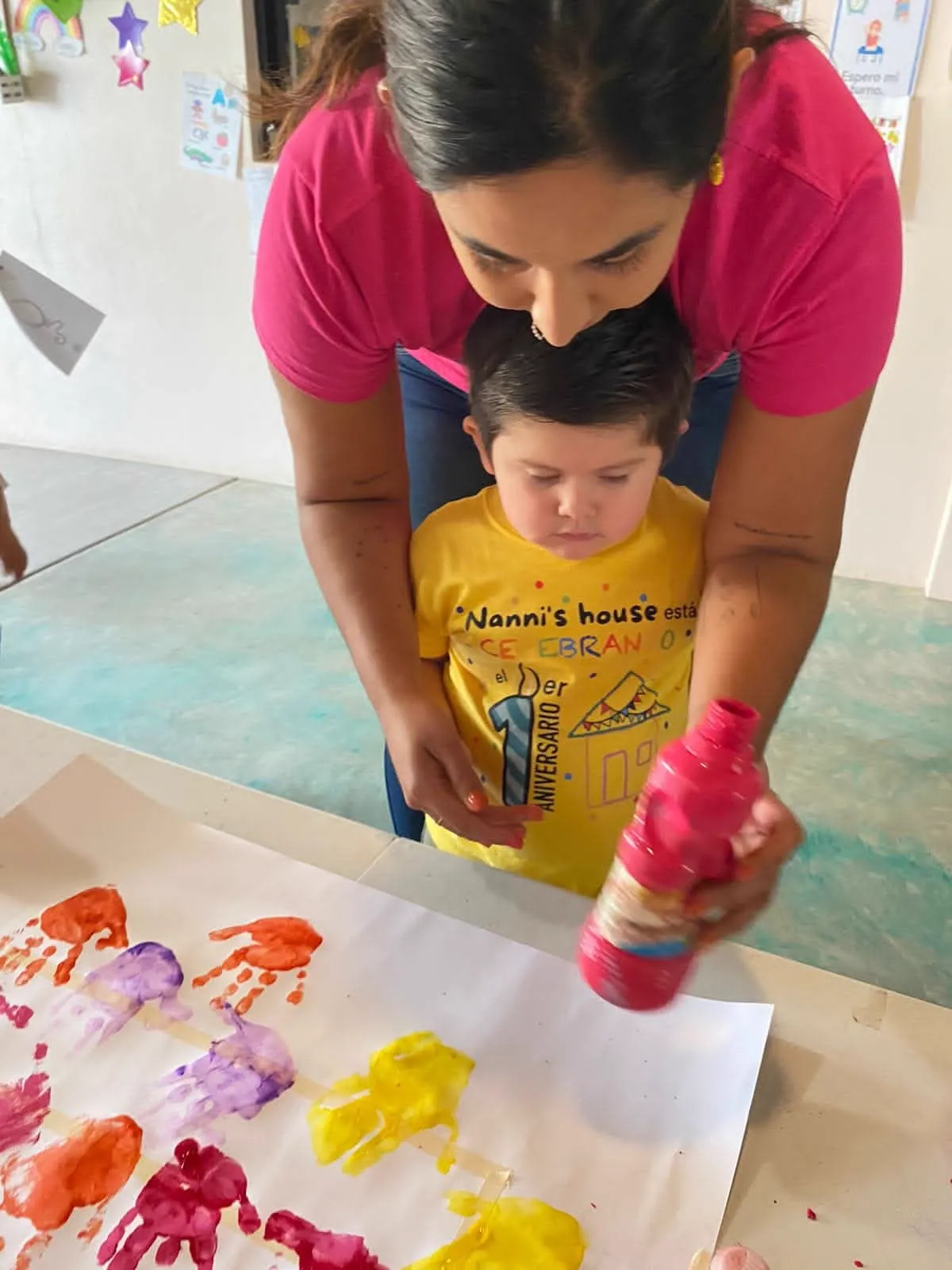 Ilse acompañando a un niño durante una actividad de pintura en Baja Kids