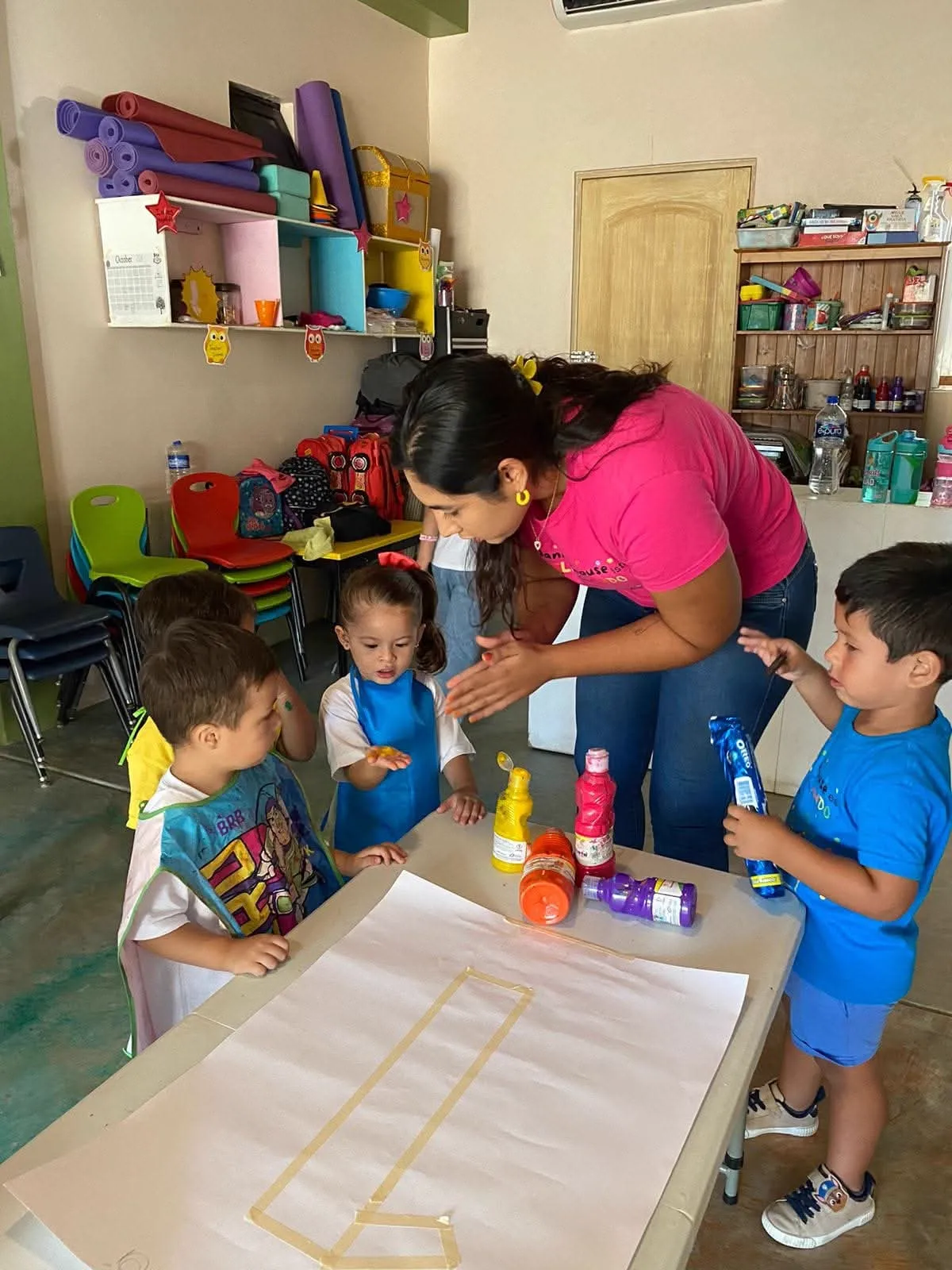 Niños pintando con Ilse alrededor de una mesa en Baja Kids