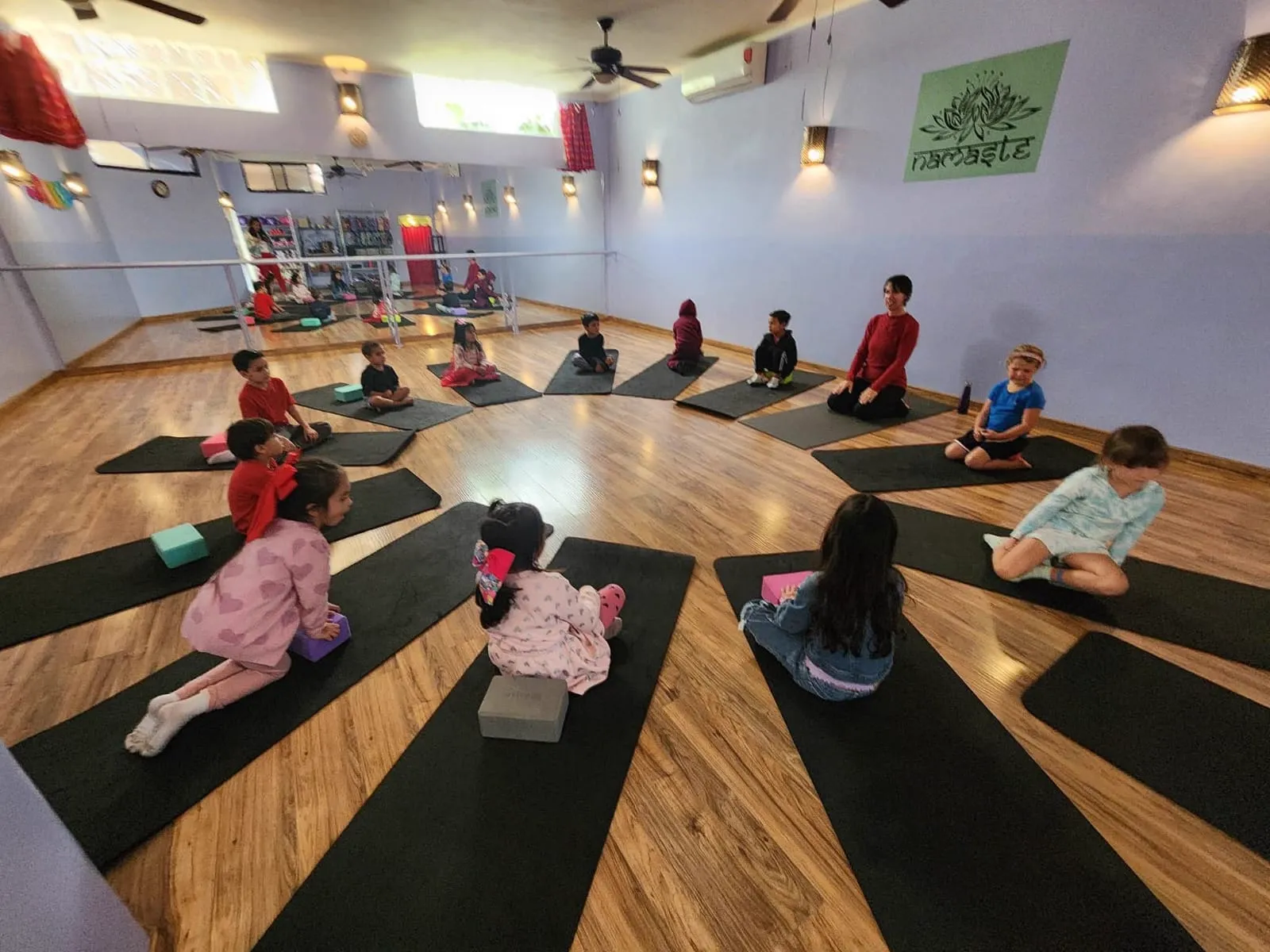 Niños sentados en círculo durante una sesión de yoga guiada